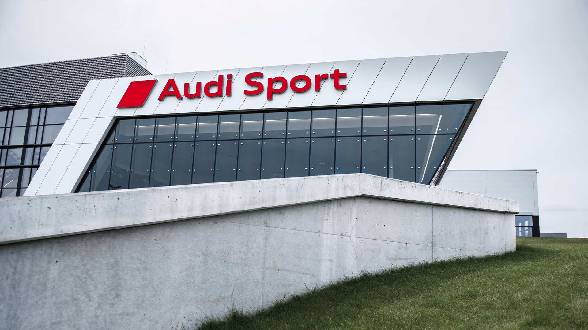 Audi Sport-bygget kan sees bak en liten vegg.
