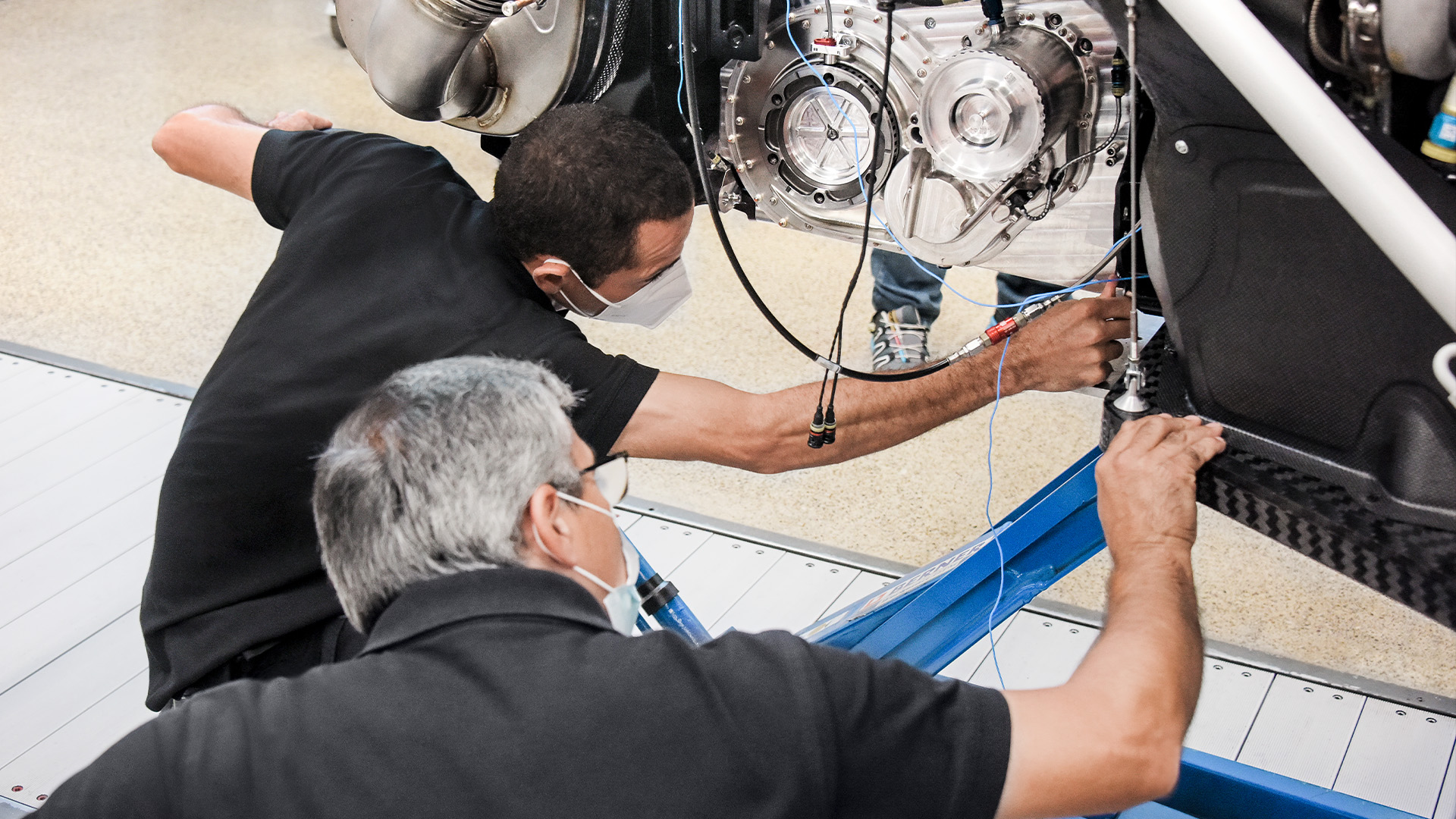 Arbeider med hjertet av Audi RS Q e-tron{ft_rs-q-e-tron}: To Audi Sport-ansatte sjekker bilens drivsystem.