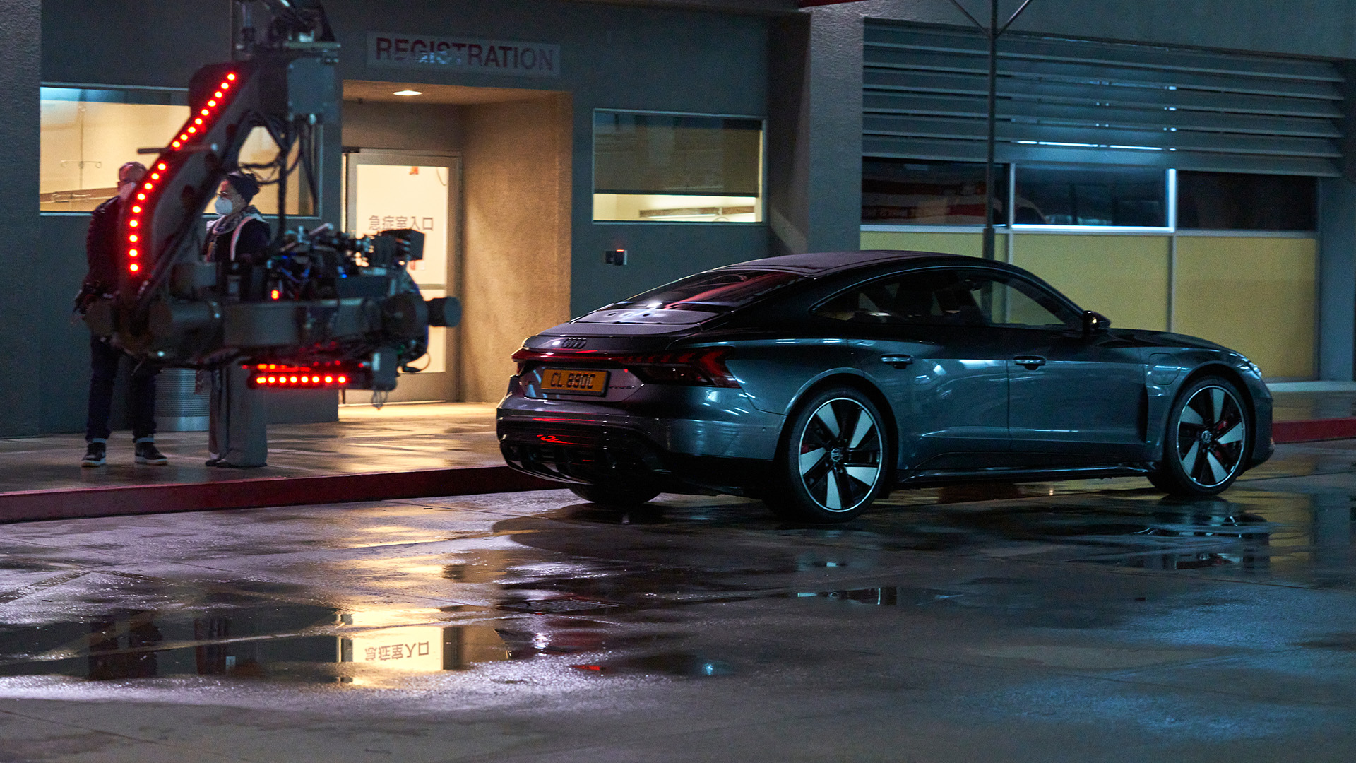 Audi RS e-tron GT{ft_rs-e-tron-gt} sett bakfra. En kameraarm kan sees i forgrunnen.