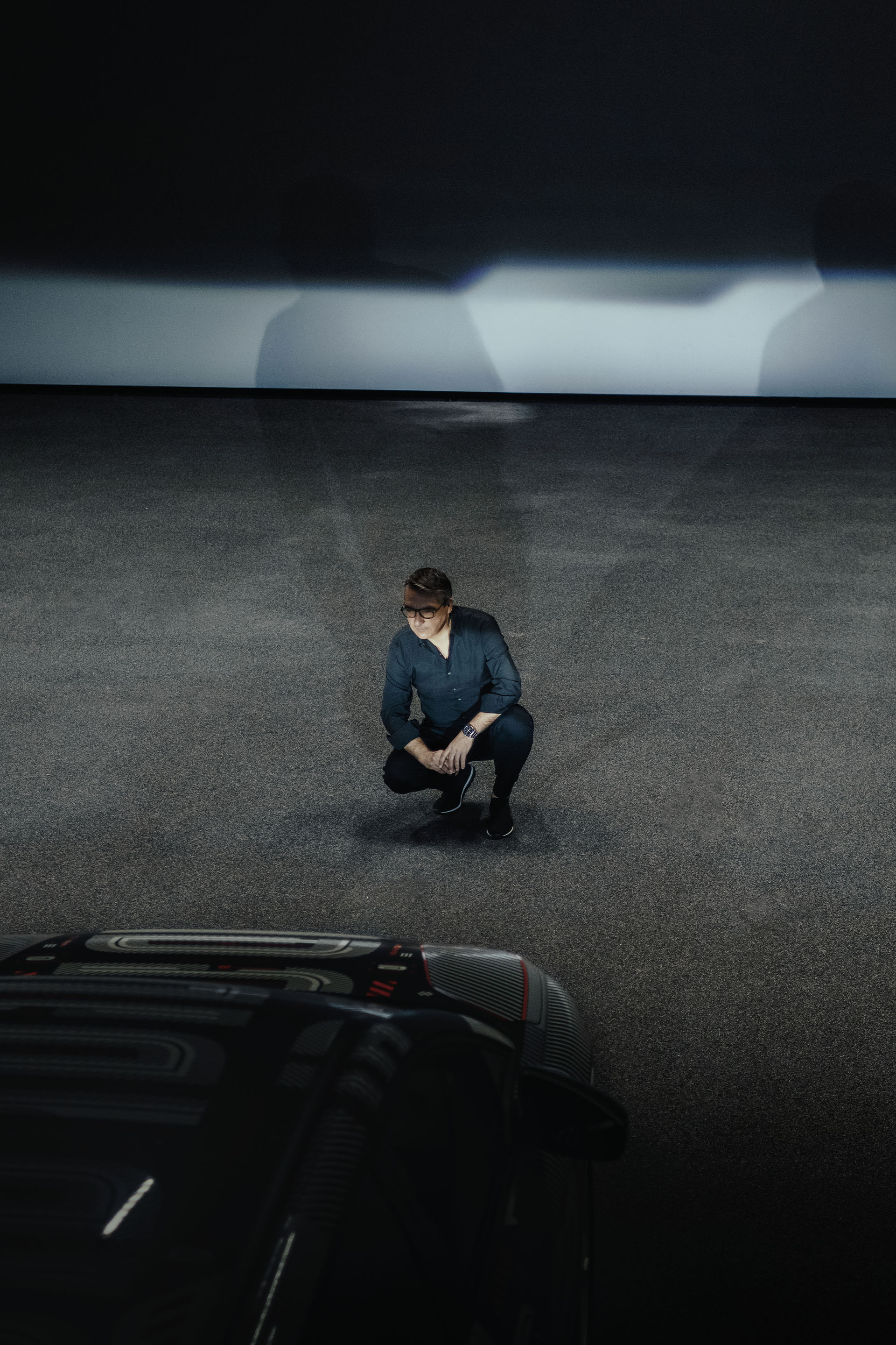 César Muntada sitter på huk og ser rett på hovedlyktene på Audi Q4 e-tron.
