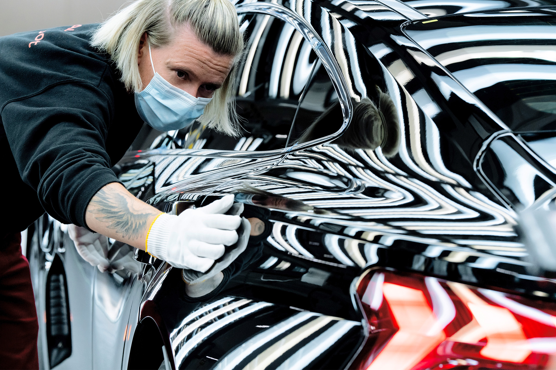 Fabrikkarbeider utfører en siste kvalitetssjekk på Audi e-tron GT quattro.